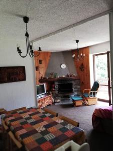 een woonkamer met een bed en een open haard bij Grande casa di famiglia in Temù