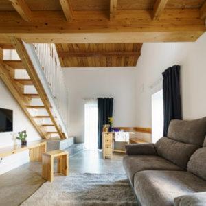 a living room with a couch and a staircase at La Isla de Próspero in Tapia de Casariego