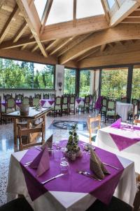 una sala da pranzo con tavoli e sedie viola e bianchi di Hotel Park Oasi ad Arta Terme