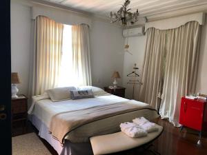 Un dormitorio con una cama grande y una ventana en Pousada Vila Brasil, en Petrópolis