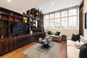 a living room with a large entertainment center and a television at Spectacular Knightsbridge House Harrods 1 minute in London