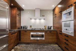 una cucina con armadi in legno e piano cottura. di Spectacular Knightsbridge House Harrods 1 minute a Londra