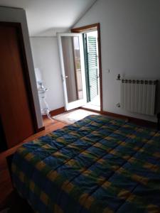 ein Schlafzimmer mit einem Bett mit einer bunten Decke darauf in der Unterkunft Casa da Estivada, 313 in Vila do Conde