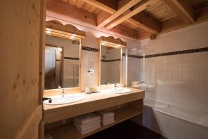 a bathroom with two sinks and a tub at Montana Chalet Hôtel & Spa in Le Sauze +47 photos