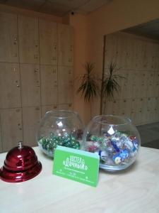 two glass bowls filled with candy on a table at Dachny Hostel на метро "Заельцовская" in Novosibirsk
