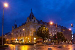a large building on a city street at night at Arany Bárány Hotel in Zalaegerszeg