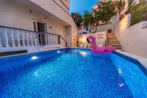 a swimming pool with a pink inflatable flamingo in a house at " Villa Kruna Lux " in Budva