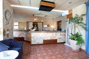 a lobby with a bar and a counter with chairs at Hotel & Spa Entre Pinos-Adults Only in Es Calo