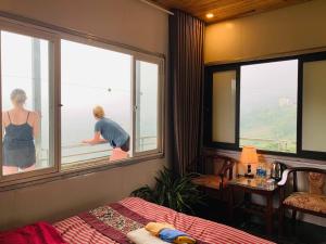 un hombre y una mujer mirando por una ventana en Sapa Dao Homestay, en Sa Pa 119 fotos más