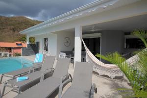 レザンセス・ダルレットにあるvilla with pool and sea view (MQAA16)の家の隣にパティオ(椅子、ハンモック付)