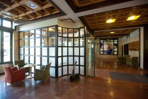 a lobby with chairs and a table and windows at Arany Bárány Hotel in Zalaegerszeg