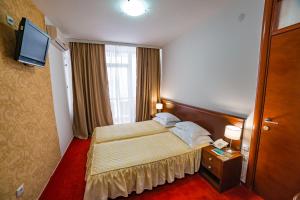 ラクタシにあるHotel San Terme Laktašiのベッドとテレビが備わるホテルルームです。