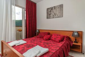 a bedroom with a red bed with red pillows at " Villa Kruna Lux " in Budva