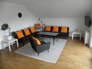 a living room with black couches and orange pillows at Island View Apartment in Bled