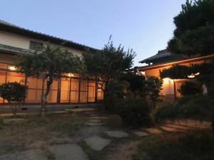 a building with windows and trees in front of it at Setouchi Guest House Taiyo and Umi in Mitoyo