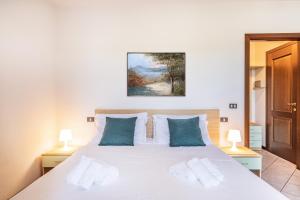 una camera da letto con un grande letto bianco con cuscini blu di Residence Nuove Terme a Sirmione