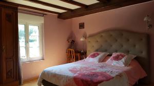 ein Schlafzimmer mit einem großen Bett und einem Fenster in der Unterkunft L ANCIEN MOULIN A GRAINS in Valmont