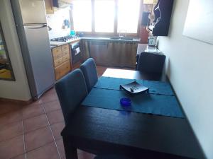 una cucina con tavolo, sedie e frigorifero di Apartment Villa Luna a Magazzini