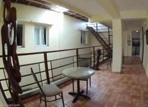 un couloir avec une table, des chaises et un escalier dans l'établissement Hotel Discovery, à Saint-Domingue