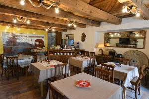 a restaurant with tables and chairs in a room at Vecchio Mulino Guest House in Aosta