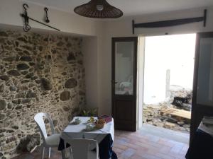 a dining room with a table and a stone wall at La Sciabica in Scilla