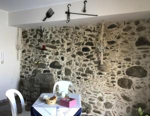 a stone wall with a table and two chairs at La Sciabica in Scilla