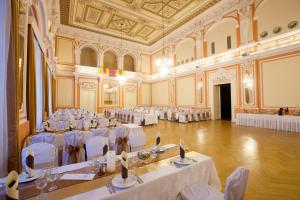 a large banquet hall with white tables and chairs at Arany Bárány Hotel in Zalaegerszeg