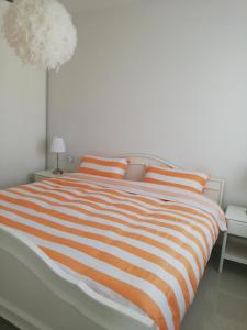 uma cama com um cobertor laranja e branco listrado em AMAY 880 Nr 38 em Torrevieja