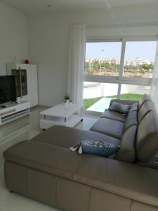 een woonkamer met een bank en een groot raam bij AMAY 880 Nr 38 in Torrevieja