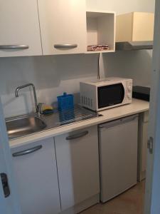 a small kitchen with a microwave and a sink at B&B Al Mulino in Nuvolento