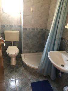een badkamer met een toilet, een wastafel en een bad bij Apartman Polegubic in Biograd na Moru