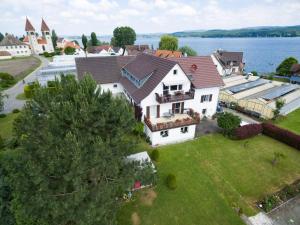 eine Luftansicht eines großen weißen Hauses auf dem Wasser in der Unterkunft Ferienwohnungen Richard Wurz in Reichenau
