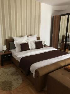 a bedroom with a large bed with white pillows at Xenopol Central in Sibiu