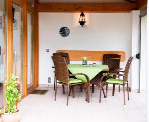 a dining room with a green table and chairs at Haus Gunda in Arrach