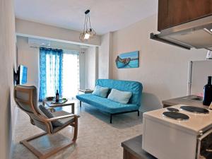 un soggiorno con divano blu e sedia di Iris Sunset Luxury Apartments - Nea Potidea Halkidiki a Nea Potidaea