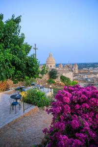 a row of benches in front of a large building at Trigona Garden Suite in Noto