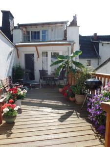 eine Holzterrasse mit Pflanzen und Blumen auf einem Haus in der Unterkunft Ferienhaus Schlupfwinkel in Bad Neuenahr-Ahrweiler