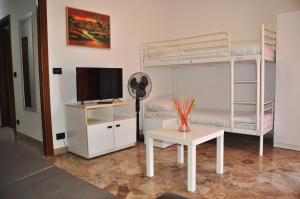a bedroom with a bunk bed and a table with a desk at Viale Repubblica 307 4 in Pietra Ligure