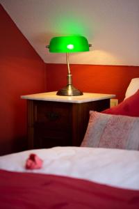 une lampe verte assise au-dessus d'un lit dans l'établissement VILLA CANTARE, à Obernburg am Main