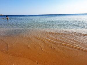 een persoon in het water op het strand bij Resort ' Njulella in Migliarello