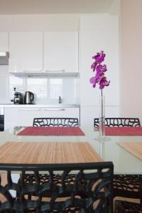 een eettafel met een vaas met paarse bloemen bij After Six Apartment in Bratislava