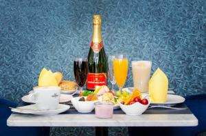 einen Tisch mit einer Flasche Champagner sowie Speisen und Getränke in der Unterkunft Monopol Boutique Hotel in Bremen