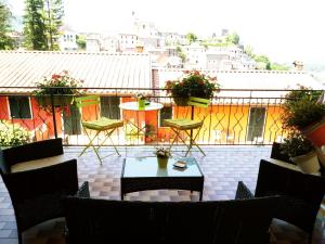 eine Terrasse mit Stühlen und einem Tisch auf dem Balkon in der Unterkunft Hotel Ristorante El Caracol in Mulazzo