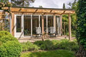 um pavilhão com uma mesa e cadeiras num jardim em B&Bveluwezoom em Eerbeek