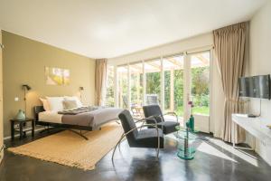 a bedroom with a bed and a living room at B&Bveluwezoom in Eerbeek