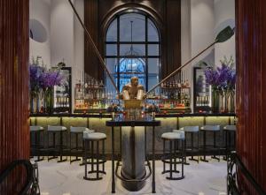 a bar with a statue of a man in a fountain at One Aldwych in London