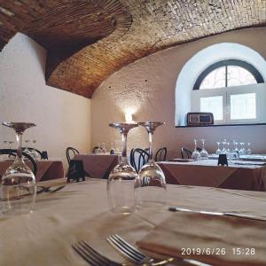 uma sala de jantar com uma mesa com copos em Il torchio antico em Arzo