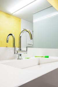 a kitchen with two sinks and two faucets at Hotel Estació in Olot