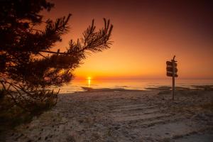 a sunset on the beach with a traffic light at Dzintarkrasts in Žocenes Ciems