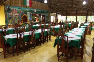 eine Gruppe von Tischen und Stühlen mit grünen Tischdecken in der Unterkunft Hotel Nueva Alianza in Frontera Corozal
